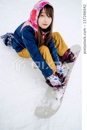 年輕女子在冬季的雪坡上享受單板滑雪的樂趣 年輕女子在冬季的雪坡上享受單板滑雪的樂趣 137266842