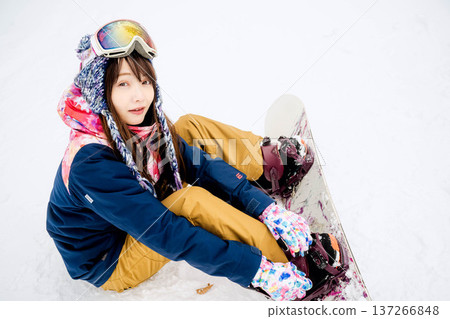 年輕女子在冬季的雪坡上享受單板滑雪的樂趣 年輕女子在冬季的雪坡上享受單板滑雪的樂趣 137266848