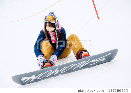 年輕女子在冬季的雪坡上享受單板滑雪的樂趣 137266853