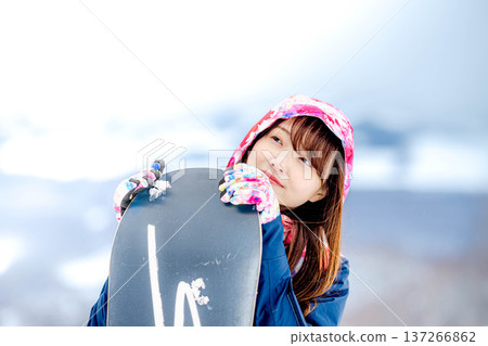 年輕女子在冬季的雪坡上享受單板滑雪的樂趣 137266862