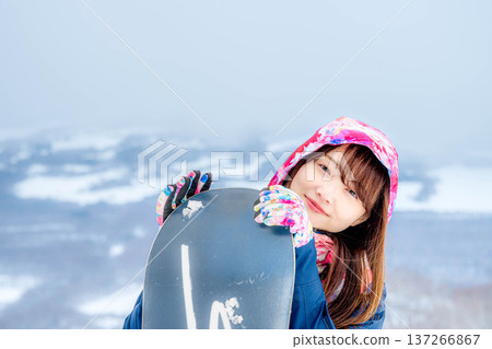 Young woman enjoying snowboarding on the slopes in winter 137266867
