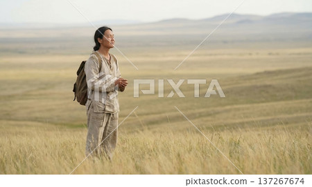 Person standing calmly on open plain with serene expression and soft daylight 137267674