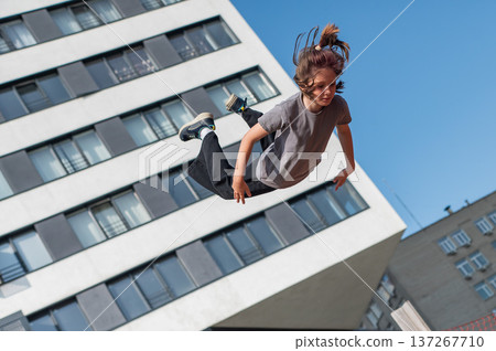 A girl jumps on an outdoor trampoline. 137267710