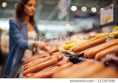 Female Shopper Browsing Packaged Sausages in Grocery Store Display Female Shopper Browsing Packaged Sausages in Grocery Store Display 137267940