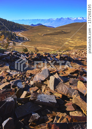 Rocky Plateau and Distant Snow Capped Mountains Under Clear Sky 137268195