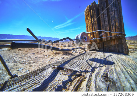 Barbed Wire Fence Post and Ceramic Insulator in California Desert Landscape 137268309