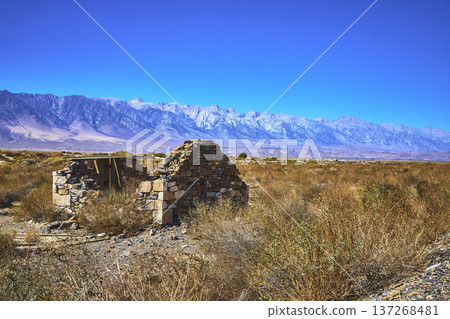 Abandoned Stone Structure Desert Brush and Mountains Under Clear Blue Sky 137268481