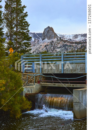 Bridge Over Waterfall and Snowy Mountain Peak with Trees and Cycling Trail 137268601