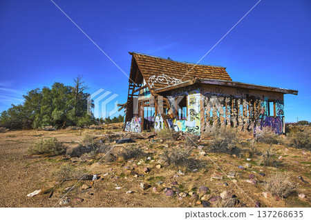 Abandoned Graffiti Covered Building in Desert Landscape Under Blue Sky Abandoned Graffiti Covered Building in Desert Landscape Under Blue Sky 137268635