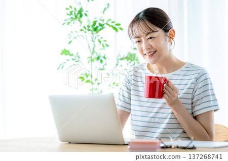 使用一台電腦在客廳裡的年輕女子 137268741