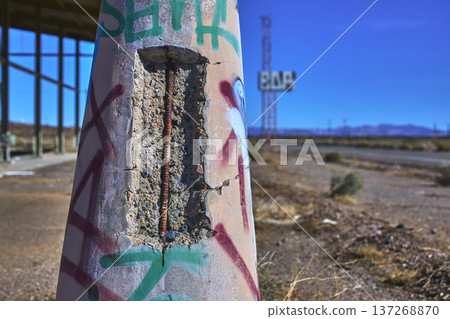 Abandoned Graffiti Covered Concrete Pillar and Faded Bar Sign in Desert California 137268870