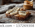 Almond Butter on Rye Toast with Banana and Hemp Seeds on Wooden Table 137269308