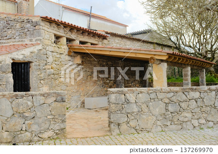 Rustic stone house exterior with tiled roof and courtyard in Fatima Portugal traditional rural architecture old masonry walls wooden beams heritage building tourism landmark no people. High quality 137269970