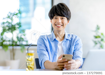 操作智能手機的一個年輕人 137270091
