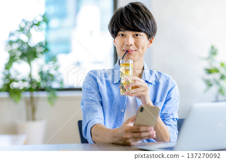 A young man operating a smartphone 137270092