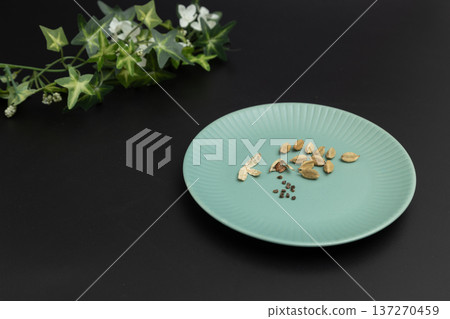 Black background and cardamom seeds. Stock photo of spices. Cardamom is said to be effective in preventing hay fever. Black background and cardamom seeds. Stock photo of spices. Cardamom is said to be effective in preventing hay fever. 137270459