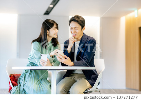A young couple searching on a smartphone A young couple searching on a smartphone 137271277