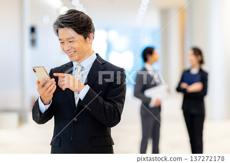 Middle-aged man looking at a smartphone Middle-aged man looking at a smartphone 137272178