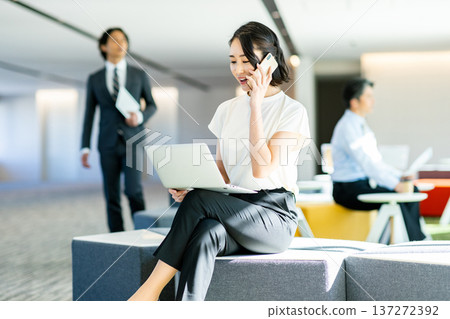 Business woman operating a smartphone in the office Business woman operating a smartphone in the office 137272392