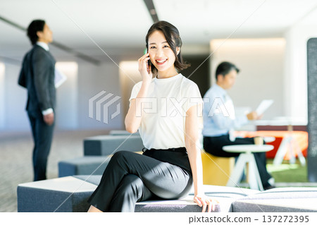 經營一部智能手機的女商人在辦公室 經營一部智能手機的女商人在辦公室 137272395