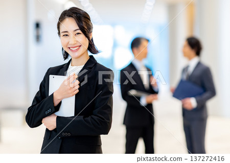 Smiling businesswoman holding a tablet 137272416