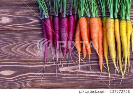 Colorful carrots Rainbow mix on the brown wooden table. Colorful carrots Rainbow mix on the brown wooden table. 137272738