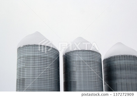 Monochrome of steel grain bins covered with snow after snowfall. 137272909
