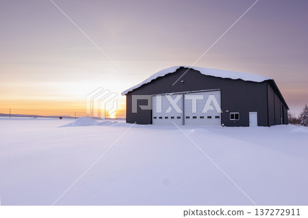 Warehouse in snow, industrial building in sunset light in winter. Warehouse in snow, industrial building in sunset light in winter. 137272911