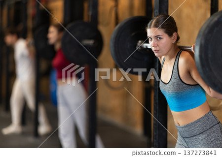 Woman doing strength training with a barbell 137273841