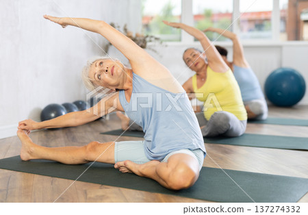 Mature lady performs pose Parivritta janu shirshasana Mature lady performs pose Parivritta janu shirshasana 137274332