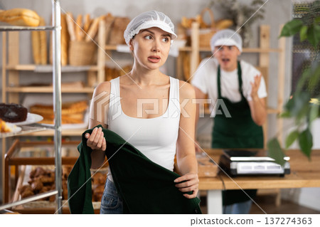 In bakery, confused female employee during quarrel with guy boss In bakery, confused female employee during quarrel with guy boss 137274363