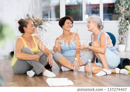 Group of elderly women talking in fitness studio Group of elderly women talking in fitness studio 137274407