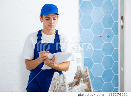 Repairman checking project documentation, planning renovation works in new apartment 137274911
