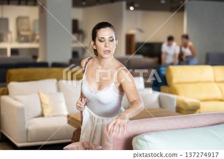 Adult woman chooses sofa in store 137274917