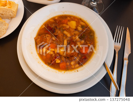 Restaurant serves chickpea and bean soup, served in portions on white plate Restaurant serves chickpea and bean soup, served in portions on white plate 137275048