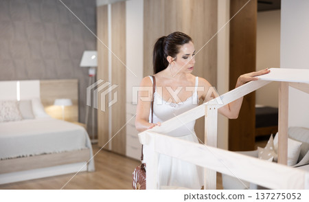Adult woman looking around in bedroom department Adult woman looking around in bedroom department 137275052