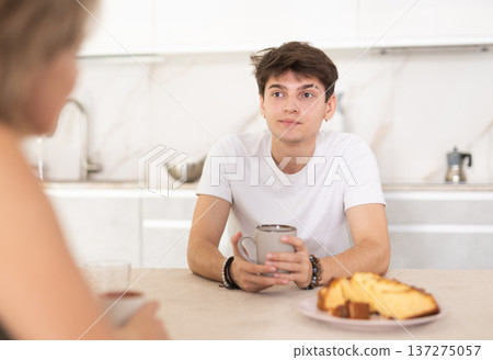 Couple sitting at kitchen table and drinking tea at home 137275057