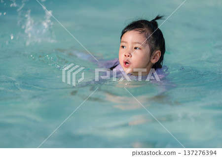 preschool child girl playing and swimming in pool preschool child girl playing and swimming in pool 137276394