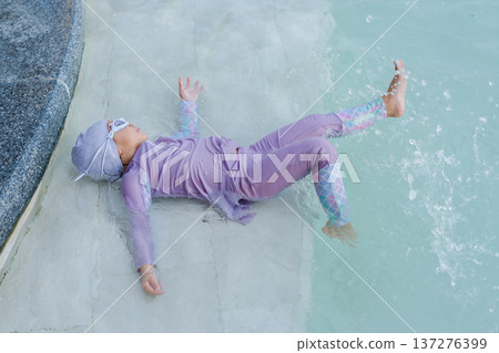 happy preschool child girl playing in swimming pool happy preschool child girl playing in swimming pool 137276399