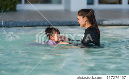 preschool child girl playing and swimming with her mother in pool preschool child girl playing and swimming with her mother in pool 137276467