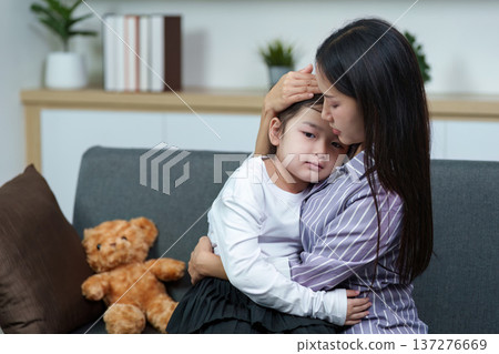 Mother comforting sick child at home. Emotional support and care. 137276669