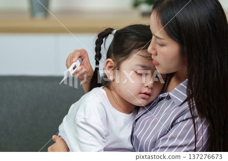 Mother checking temperature of sick daughter. Caring health support. Mother checking temperature of sick daughter. Caring health support. 137276673