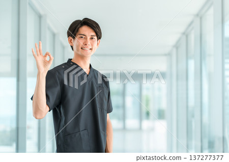 Young Asian male doctor, nurse, caregiver, and emergency physician wearing scrubs Young Asian male doctor, nurse, caregiver, and emergency physician wearing scrubs 137277377