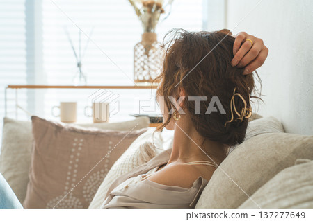 Stylish housewife Asian woman relaxing on the sofa in the living room Stylish housewife Asian woman relaxing on the sofa in the living room 137277649