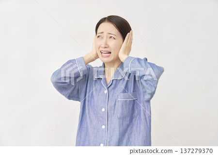 穿著睡衣遮住耳朵的女人白色背景 137279370