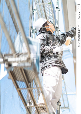 Worker painting exterior walls, no face Worker painting exterior walls, no face 137279481