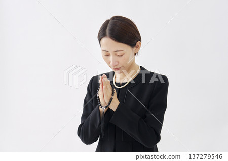 Woman in mourning clothes praying white background Woman in mourning clothes praying white background 137279546