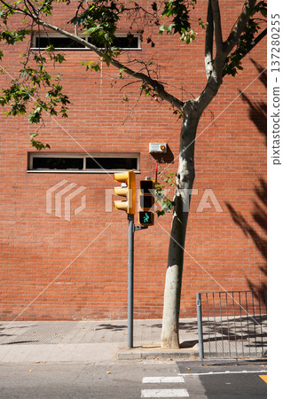 Green pedestrian traffic light and brown brick wall street background, Barcelona Spain Green pedestrian traffic light and brown brick wall street background, Barcelona Spain 137280255
