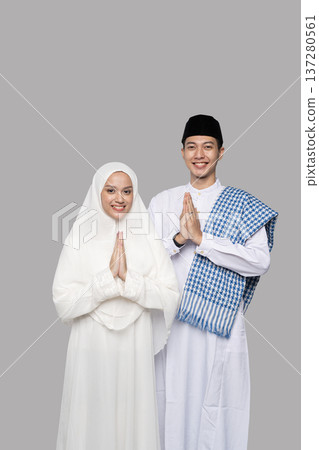Peaceful Muslim couple praying. Tranquil Muslim couple performing traditional prayer gesture Peaceful Muslim couple praying. Tranquil Muslim couple performing traditional prayer gesture 137280561