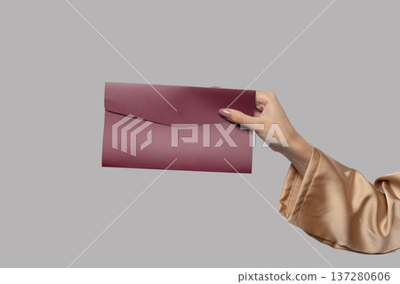 Studio shot displaying feminine hand presenting upscale invitation Studio shot displaying feminine hand presenting upscale invitation 137280606